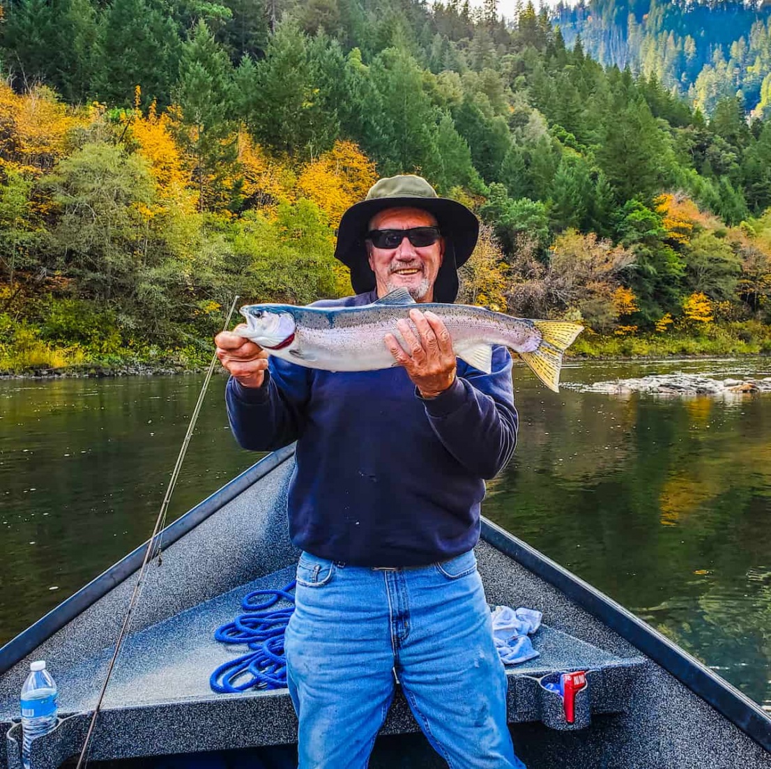 Man with fish in a drift boat on the Rogue River